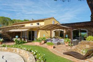 a garden with a patio and a house at Parfum de Roses in Cogolin