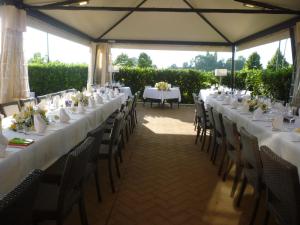 a long table with white tables and chairs in a marquee at Hotel La Fornace in San Vicenzo di Galliera