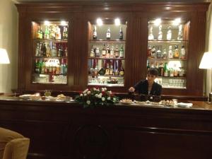 Una donna in piedi dietro un bar in un ristorante di Hotel Executive a Firenze