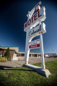 una señal para un motel frente a un edificio en Motel Colonial en Rimouski