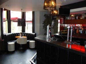 a bar in a restaurant with a counter and chairs at Whites Hotel in Newcastle upon Tyne