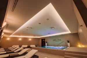 a pool in the middle of a room with chairs at Villa Plaza Boutique Hotel & Spa in Prešov