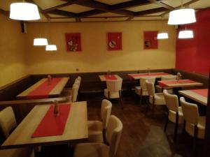 a restaurant with tables and chairs with red napkins at Gaststätte Peperoni in Biberach an der Riß