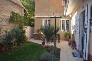 une cour d'une maison avec une table et des plantes dans l'établissement Amido Zen, à Toulouse