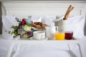 a tray with breakfast foods and drinks on a bed at Golden Star City Resort in Perea