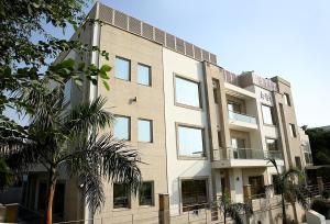 un edificio con una palmera delante en Inde Hotel Vista Woods Huda City Centre, Gurgaon, en Gurgaon