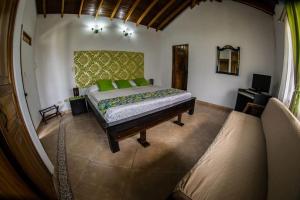 a bedroom with a bed with green pillows at Hotel La Coqueta in Montenegro