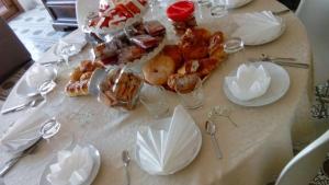 una mesa con un mantel blanco con comida. en B&B Casamiranapoli, en Nápoles