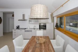 a kitchen with a wooden table and white chairs at Apartments Mengore in Tolmin