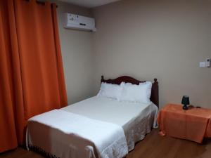 a bedroom with a bed and an orange curtain at Chamarel Mirador Studio in Chamarel