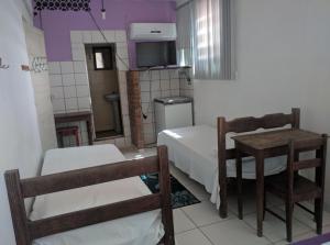 a small room with a bed and a table and chairs at Hotel Minas in Itamaraju