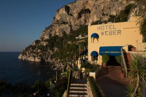 a hotel on the side of a mountain next to the ocean at Hotel Weber Ambassador in Capri