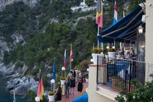 a group of people standing on a balcony overlooking the water at Hotel Weber Ambassador in Capri +37 photos