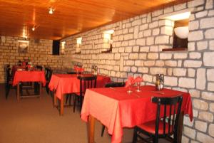 un restaurante con mesas y sillas rojas y una pared de ladrillo en Taverne de la paix en La Ferté-Macé