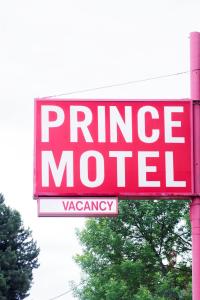 a red prime motel sign on a pole at Prince Motel in Prince George