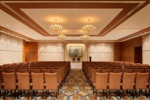 a conference room with rows of chairs and a painting at Radisson Blu Plaza Hotel Hyderabad Banjara Hills in Hyderabad +138 photos