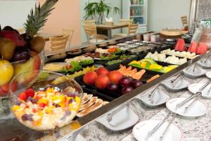 a counter filled with lots of different types of food at Serras Hotel in Cuiabá