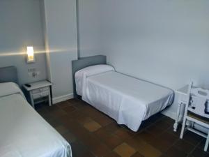 Habitación de hotel con 2 camas y mesa en Hotel Montesol Arttyco, en Sierra Nevada