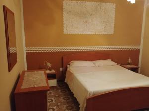 1 dormitorio pequeño con 1 cama y 2 mesas en Il Sole nel Cilento en Santa Maria di Castellabate