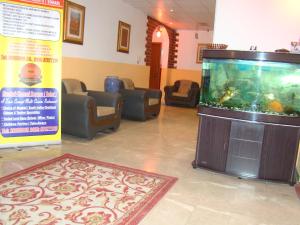 a waiting room with a large fish tank in a room at Atlas Hotel Apartments in Sohar