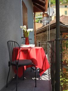 カンネロ・リヴィエーラにあるCasa Luciaのバルコニーにテーブルと赤いテーブルクロス