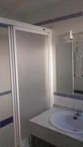 a bathroom with a sink and a shower with a mirror at Hostal Juanito in Móstoles