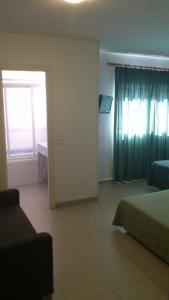 a bedroom with a bed and a window and a door at Hostal Juanito in Móstoles