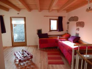 sala de estar con sofá rojo y mesa en Casa delle Antiche Pietre, en Cannero Riviera