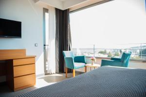 a bedroom with a bed and two chairs and a television at Port Marina Hotel in Karatas