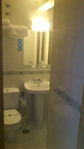 a bathroom with a sink and a toilet and a mirror at Hostal Juanito in Móstoles +24 photos