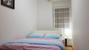 una camera da letto con un letto con cuscini blu e una finestra di Apartment MA a Banja Luka