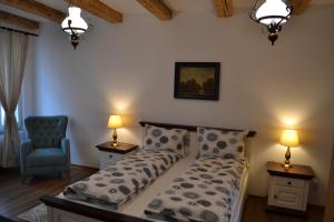 a bedroom with a bed and a chair and lamps at Casa Fanarilor in Braşov