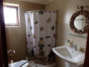 a bathroom with a shower curtain with shells on it at Ravdoucha Beach Studios in Ravdhoúkha
