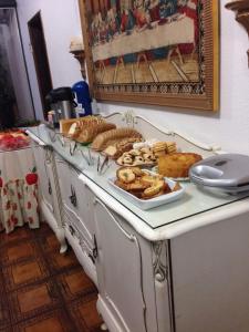 a table with a tray of bread and pastries on it at Turis Hotel in Santo Ângelo