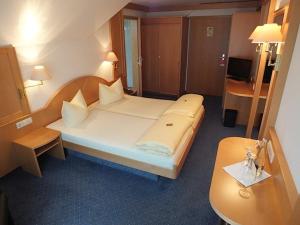 a hotel room with a large bed and a desk at Achkarrer Krone in Achkarren