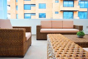 un patio con sillas de mimbre y un sofá en el balcón en San Juan Hotel Boutique Pasto, en Pasto