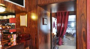 a room with wooden walls and a doorway with a red curtain at Logis Hôtel-Restaurant La Croix Couverte in Mayenne