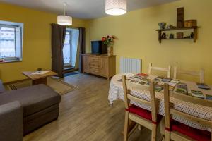 ein Wohnzimmer mit einem Tisch und einem Sofa in der Unterkunft Appartement avec terrasse "BARTHOLDI" in Colmar