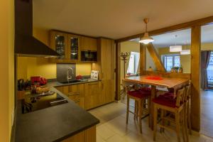 eine Küche mit Holzschränken und eine Insel mit Barhockern in der Unterkunft Appartement avec terrasse "BARTHOLDI" in Colmar