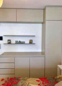 a kitchen with white cabinets and a shelf at Ocio Laprida in Buenos Aires