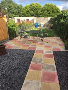 a patio with a table and chairs on a colorful floor at Snowdon Cottage in Caernarfon