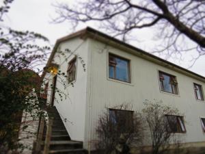uma casa branca com escadas que levam até ela em Guesthouse Kálfafellsstadur em Kálfafellsstaður