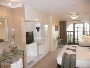 a bathroom with a bed and a sink in a room at Getaway Inn Boutique Guest house in Nulkaba