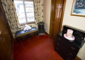 Cette chambre dispose d'une fenêtre, d'un banc et d'une commode. dans l'établissement Madonna Inn, à San Luis Obispo