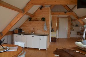 een keuken met witte kasten en een houten plafond bij B&B Nieuwe Brug in Vijfhuizen