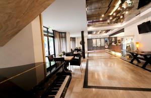 Una sala de estar con un piano y una mesa. en Fletcher Hotel-Restaurant de Korenbeurs, en Made