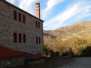 un edificio di mattoni con una torre sul lato di Ξενώνας Αριάδνη - Guesthouse Ariadni a Laimós