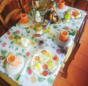 a table with plates of food and cups on it at Drapers San Guest House in Port Antonio