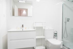 bagno bianco con lavandino e servizi igienici di Bracara Guest House "D. Pedro V" a Braga