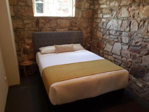 uma cama num quarto com uma parede de pedra em The Richmond Arms Hotel em Richmond